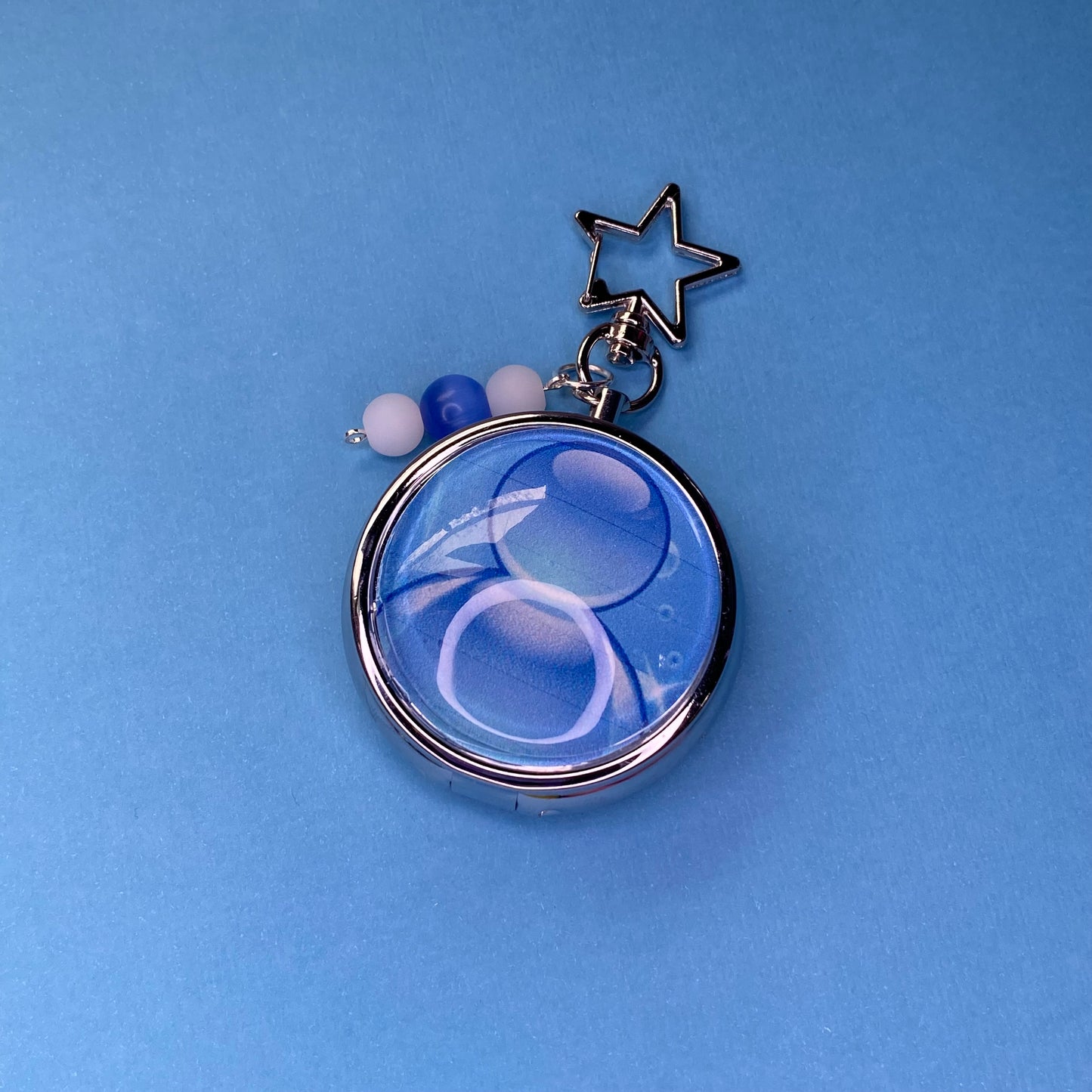 Blue Frutiger aero icon keychain pill case